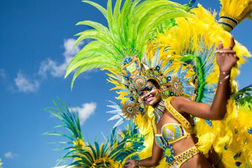 Carnival performer wearing a colorful feathered costume in Aruba